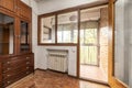 Living room of a house with old and ugly style wooden furniture and access to a glazed terrace with door and internal windows with Royalty Free Stock Photo