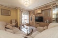 Living room of a house with a sofa with a bright chaise longue upholstered in beige fabric in front