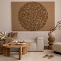 Living room interior with mock up poster frame, beige sofa, round wooden coffee table, rug, pouf, vase with rowan, rounded shapes Royalty Free Stock Photo