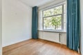 a living room with a large window and blue curtains