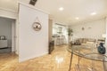 Small living room in a house with circular metal coffee table, beige fabric sofa, open loft-style kitchen and herringbone-shaped Royalty Free Stock Photo