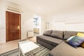 Living room of a loft-style rental house with a sofa with a trundle bed and a gray fabric chaise longue with cushions and