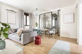 Living room with narrow white carpet, gray sofas, wooden dining