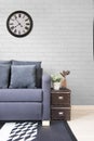 Living room, navy blue satin sofa with boxes and white brick wall. decorate in loft style.