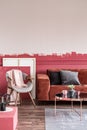 Living room with ombre wall, stylish grey chair with pastel ink blanket and brown velvet sofa Royalty Free Stock Photo