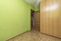 living room with plain green painted walls, built-in wardrobe with two wooden