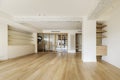 Large empty modern living room of a residential home with light wooden floors, exposed concrete beams and a terrace with sliding Royalty Free Stock Photo