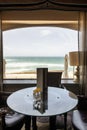 Living room with a round glass table with leather armchairs next to a window through which you can see the waves of the Atlantic Royalty Free Stock Photo