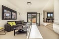 Living room of a single-family home with smooth walls painted white, seating area with chaise longe upholstered in gray fabric and Royalty Free Stock Photo