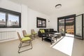 Living room of a single-family home with smooth walls painted white, a seating area with a chaise longe upholstered in gray fabric Royalty Free Stock Photo