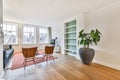 a living room with two chairs and a large plant