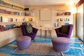 Living room with two large purple armchairs and wooden bookcase Royalty Free Stock Photo