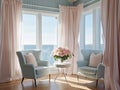 A living room with 2 wingback chairs with stained wood legs in front of a large window overlooking the ocean.