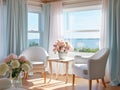 A living room with 2 wingback chairs with stained wood legs in front of a large window overlooking the ocean.