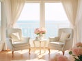 A living room with 2 wingback chairs with stained wood legs in front of a large window overlooking the ocean.