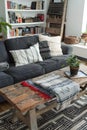 Living room with a wooden couch, rectangle coffee table, plant, and flooring