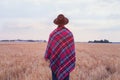 Living rural, countryside style, man in hat covered in cozy checkered plaid