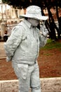 A living statue of an Italian ganster, asking for handout and keeping revolvers