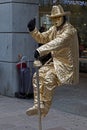 Living statue of a man seated on a invisible chair