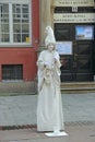 Living statue standing on street of Gdansk. Woman mime working outdoors