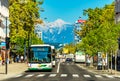 Slovenia: View of a street with public transport, crosswalk, modern architecture and the snowy Alps in the background