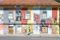 Ljubljana, Slovenia - August 16, 2018: A cyclist pass by a graffited and colorful old building in a sunny day