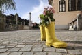 LJUBLJANA/SLOVENIA, AUGUST 17, 2019 Yellow boots with flowers stand along an old town road