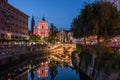 Ljubljana, Slovenia - Illuminated Tromostovje bridge and Franciscan Church of the Annunciation with Ljubljanica river at dusk Royalty Free Stock Photo