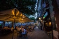 Selective blur on a packed patio of a cafe restaurant with people sitting, in evening nightlife, not respecting social distancing Royalty Free Stock Photo