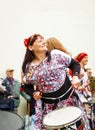 Woman in colorful outfit playing on a drum