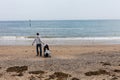 LLandudno, Wales, UK - MAY 27, 2018 Father with baby in baby carriage walking on the beach. Single parent with baby on the seashor