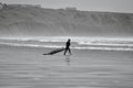 Surfers walking towards the water`s edge at Llangennith Beach on the Gower Peninsula