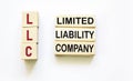 LLC - limited liability company text on wooden blocks on a white background. Finance and economics concept Royalty Free Stock Photo
