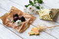 A llittle present, fresh flowers and some chocolate candies on a white wooden surface