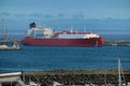 LNG carrier moored by pier in port on hazy evening.