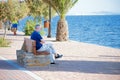 Lo PagÃÂ¡n, Murcia, Spain, June 22, 2020: Senior gentleman seated on a wooden bench watching Lo Pagan seascape in Murcia Spain,