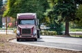 Loaded big rig semi truck with flat bed semi trailer turning from highway road to rest area parking lot for take a brake Royalty Free Stock Photo