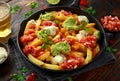 Loaded potato nachos with melted cheddar cheese, sour cream, tomato salsa, chilli, guacamole and beer