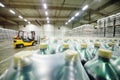 loader on the background of a huge industrial food warehouse with plastic PET bottles with beer, water, drinks. Royalty Free Stock Photo