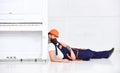 Loader lean on piano instrument. Man with beard, worker in overalls and helmet fall asleep tired, white background Royalty Free Stock Photo