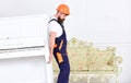 Loader moves piano instrument. Heavy loads concept. Courier delivers furniture, move out, relocation. Man with beard Royalty Free Stock Photo