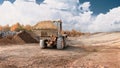 A loader is moving dirt on a construction site during daytime. The scene shows an open area with earth moved and clouds in the sky Royalty Free Stock Photo