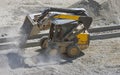 Loader small bulldozer moving breakstone at construction area Royalty Free Stock Photo