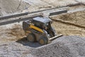 Loader small bulldozer moving breakstone at construction area Royalty Free Stock Photo