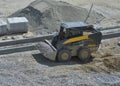 Loader small bulldozer moving breakstone at construction area Royalty Free Stock Photo