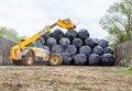 Loader tractor stacking round bales in a stack