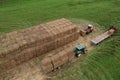 Loader at unload round bales of straw from hay trailer. Store hayat farm. Hay Forage feed for beef and dairy cattle. Making hay in