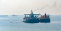 Loading anchored oil supertanker via a ship-to-ship oil transfer