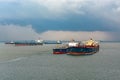 Loading anchored oil supertanker via a ship-to-ship oil transfer