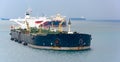 Loading anchored oil supertanker via a ship-to-ship oil transfer